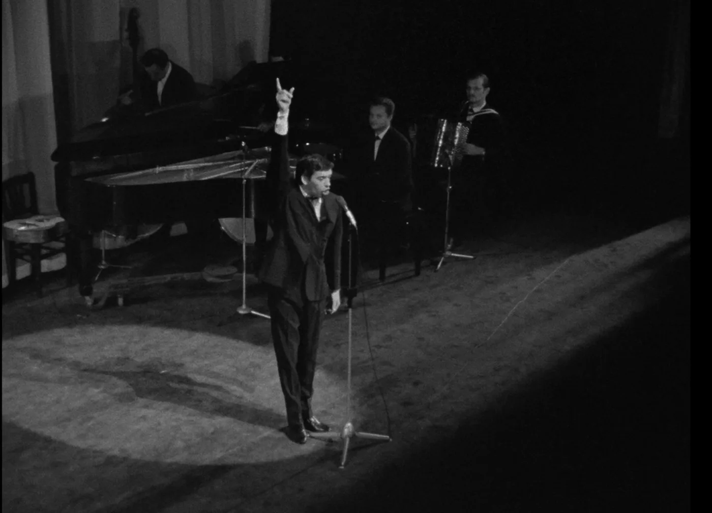Jacques Brel sur scène, le bras levé